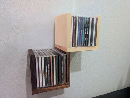 Wall-mounted CD holder with CDs on a light gray wall